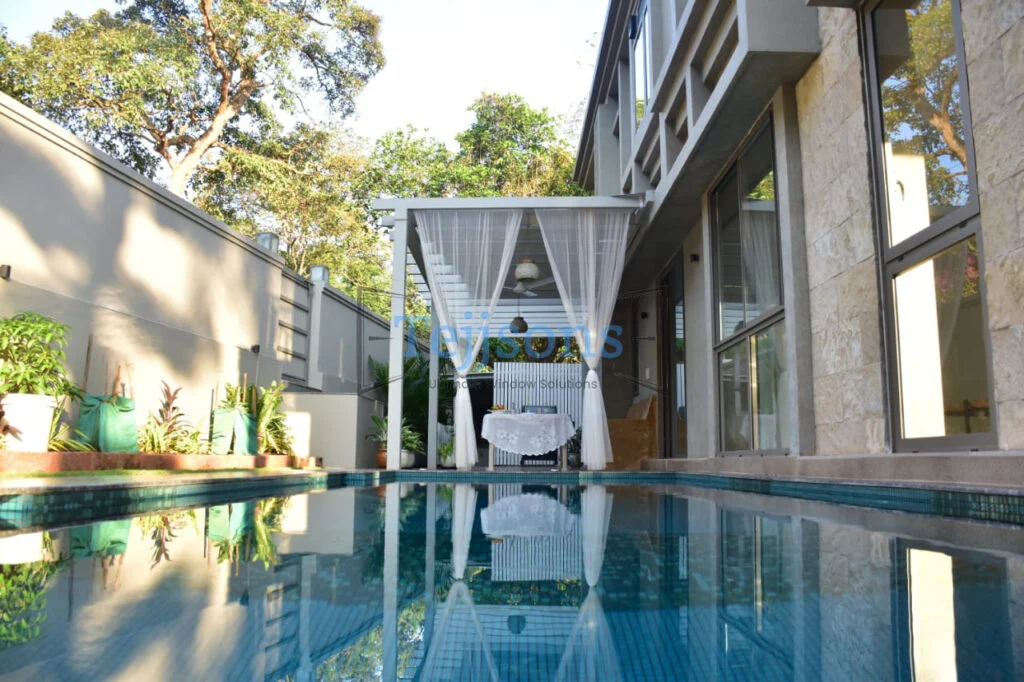 House with glass casement windows beside swimming pool